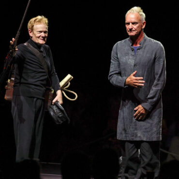 watch-sting-perform-as-philippe-petit-walks-a-tightrope-on-50th-anniversary-of-his-twin-towers-highwire-stunt